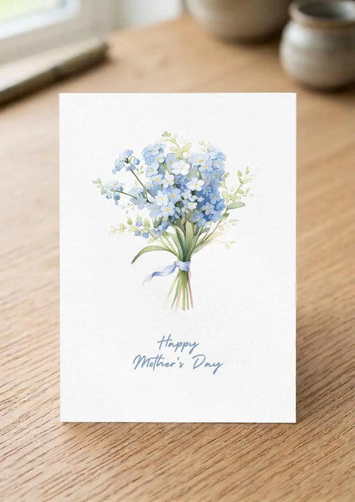 Greeting card with a bouquet of flowers and 'Happy Mother's Day' text on a wooden surface.