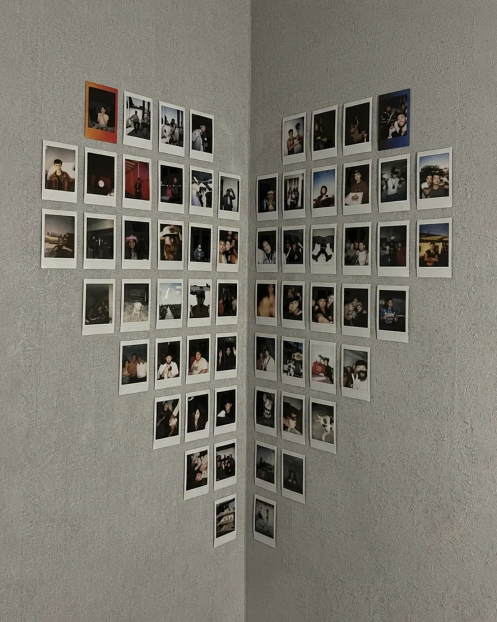 Heart shaped polaroid wall display with 62 polaroids arranged in corner wall Pakistan by The Love Language