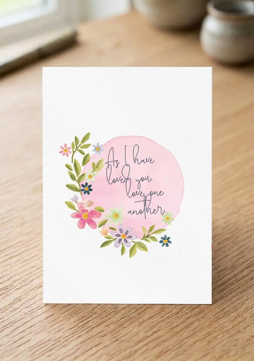 Greeting card with floral design and text on a wooden surface