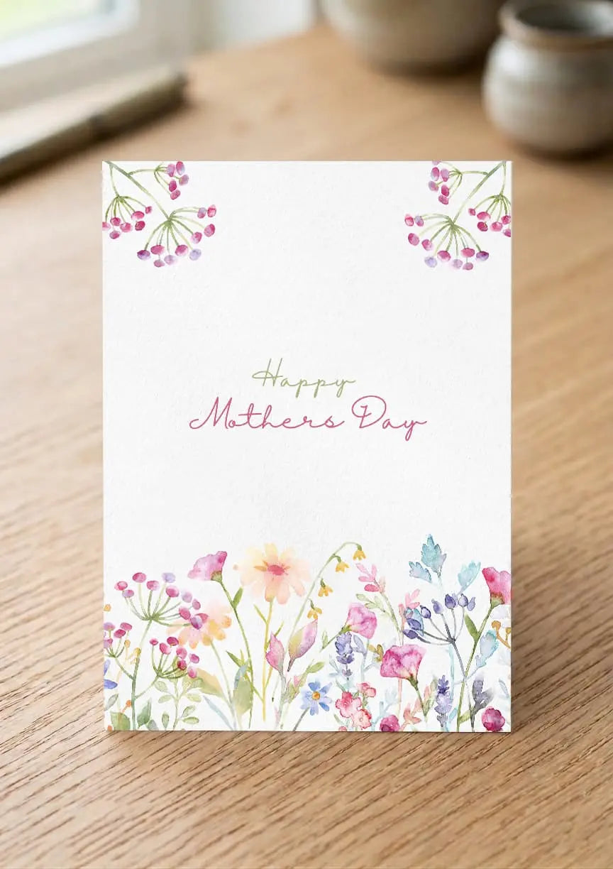 Greeting card with floral design and 'Happy Mother's Day' text on a wooden surface