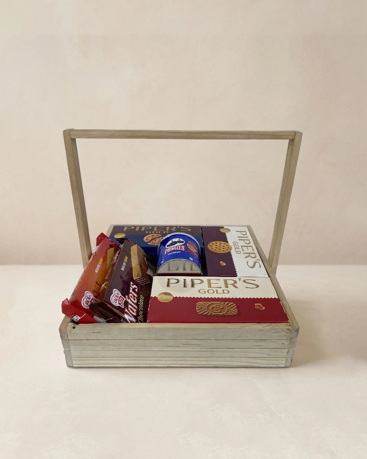 Wooden 12x12 Piper's Gold snack gift tray with Caramel Delight, Shortbread, Chocolate Chip cookies, Pringles and Jack n Joy wafers by The Love Language Pakistan