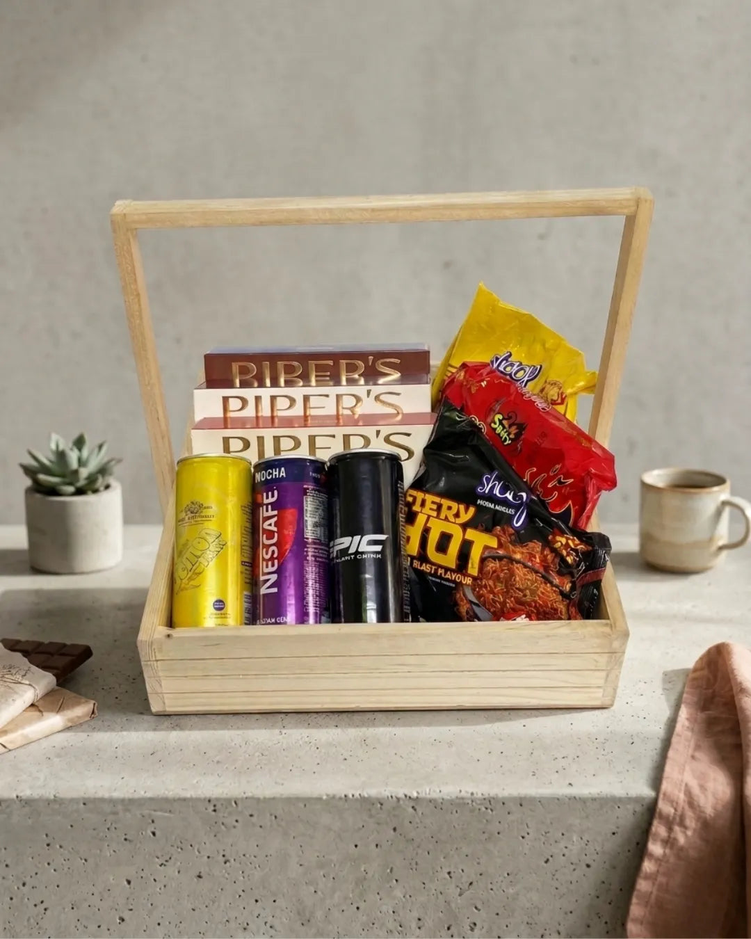 Gift basket with snacks and coffee on a concrete surface